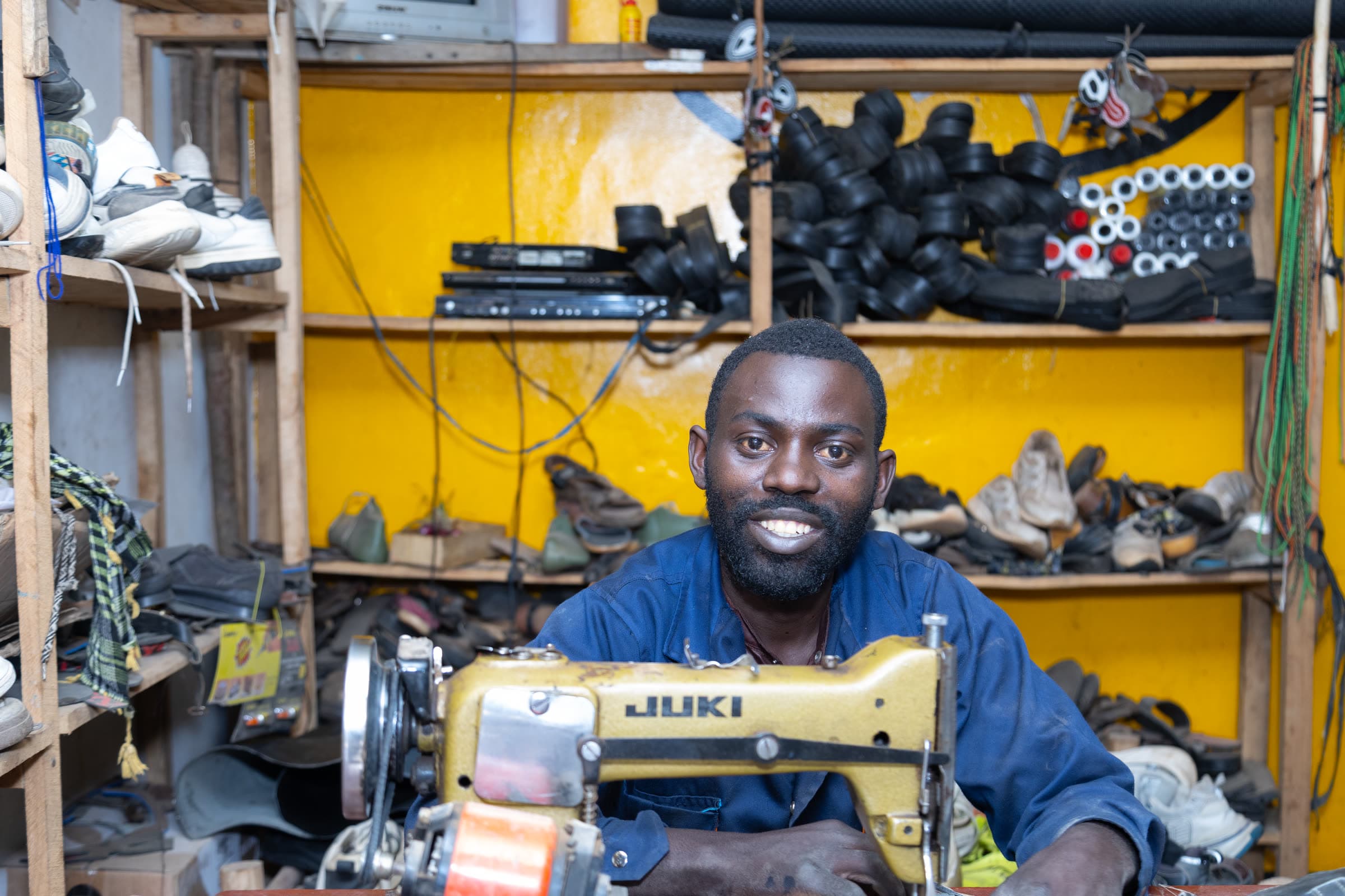A tailor at his sewing machine in his own workshop